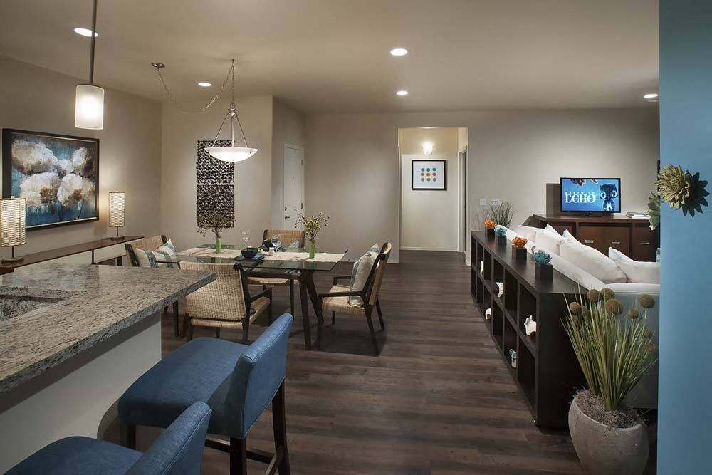 a living room and dining room with a table and chairs