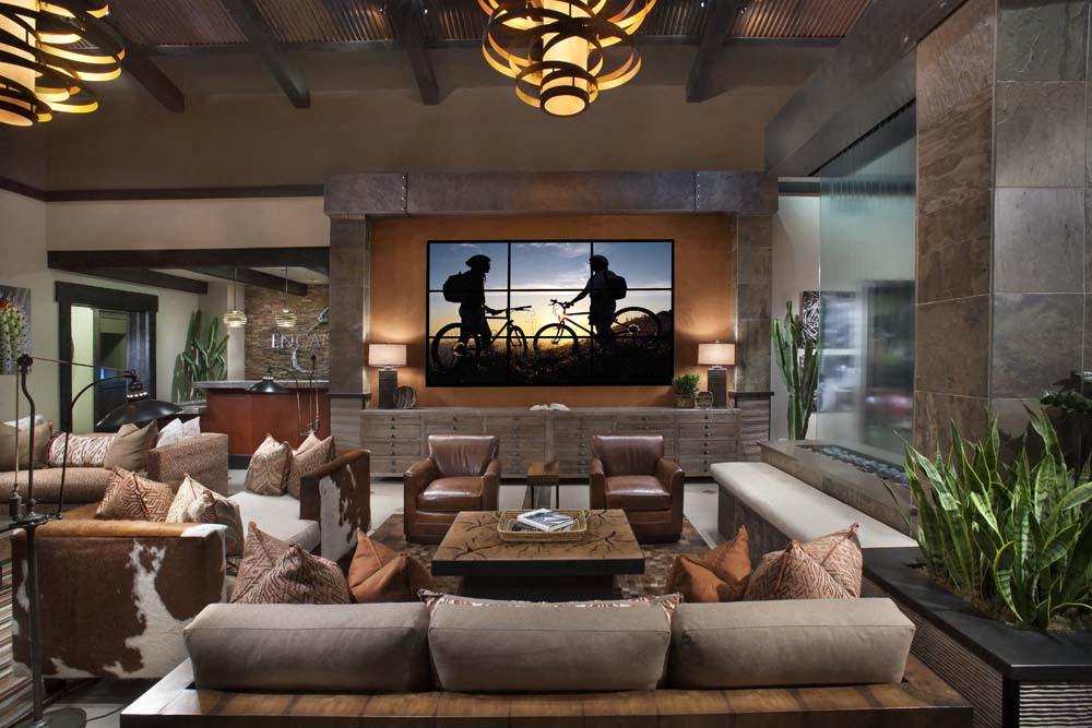 a living room with couches and chairs and a tv on the wall