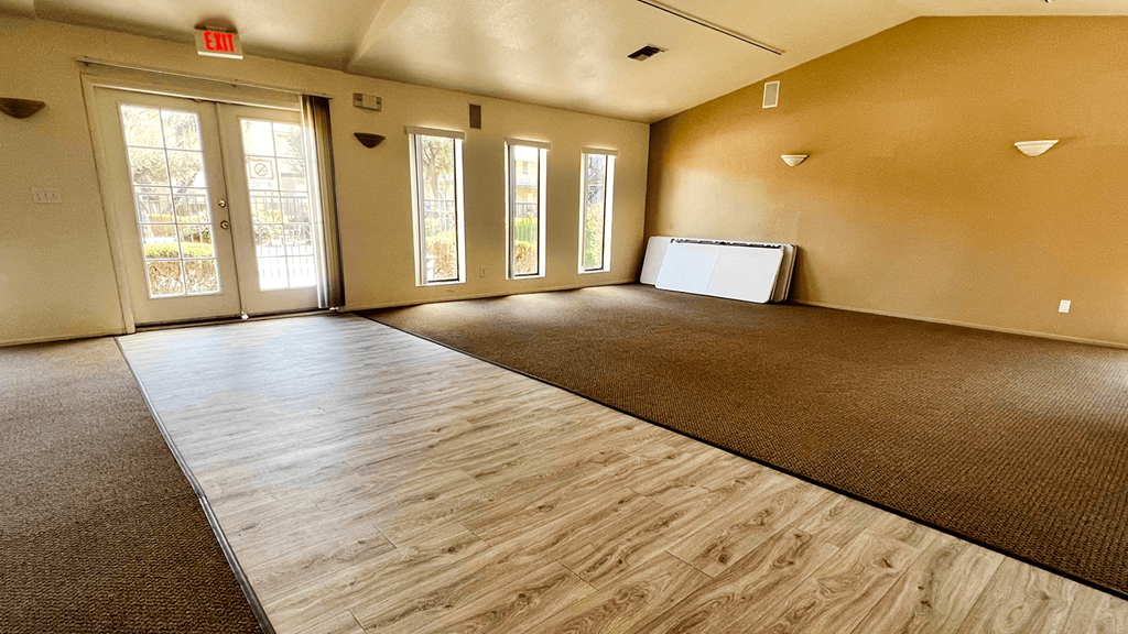an empty living room with a couch and a refrigerator