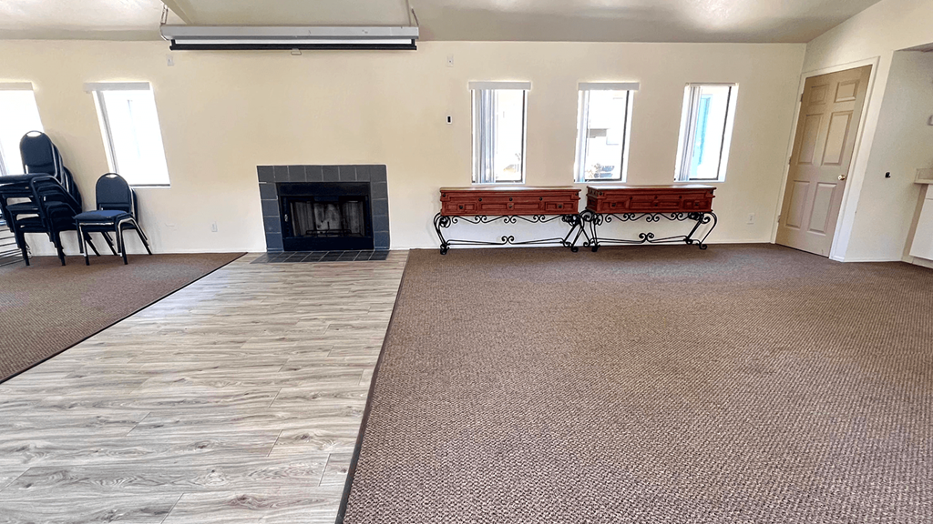 a living room with a fireplace and three windows