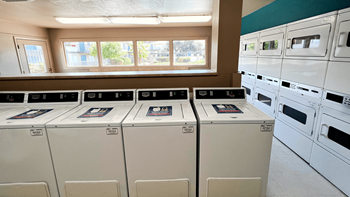 a laundry room with rows of washers and dryers - Photo Gallery 32