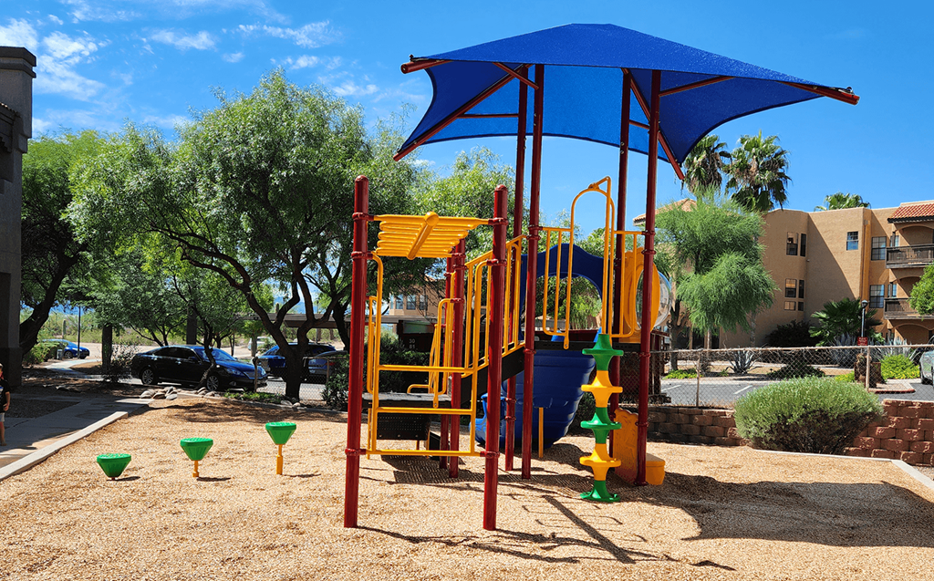 a colorful playground in a park with trees in the background