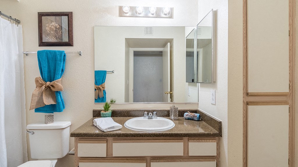 Cantera bathrooms with vanity sinks and shower tub combo