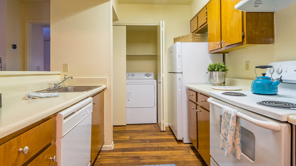 Enclave kitchen with plenty of cabinetry, a fridge, a sink, and dishwasher