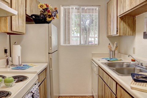 A kitchen with wooden cabinets and a white refrigerator.