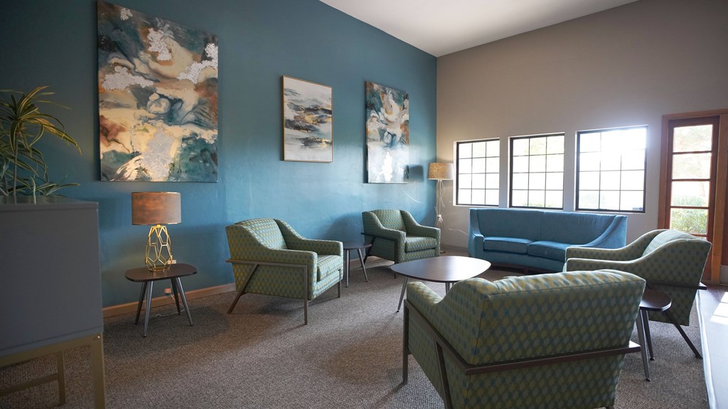 A living room with blue walls and green chairs.