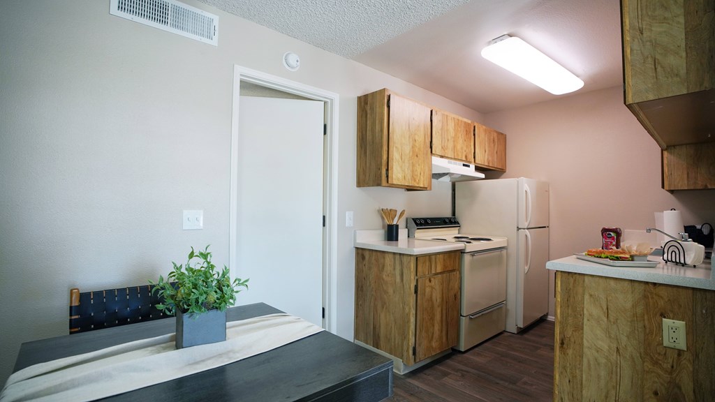 A kitchen with wooden cabinets and a white refrigerator.