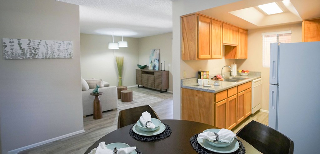 A kitchen with wooden cabinets and a dining table set for two.