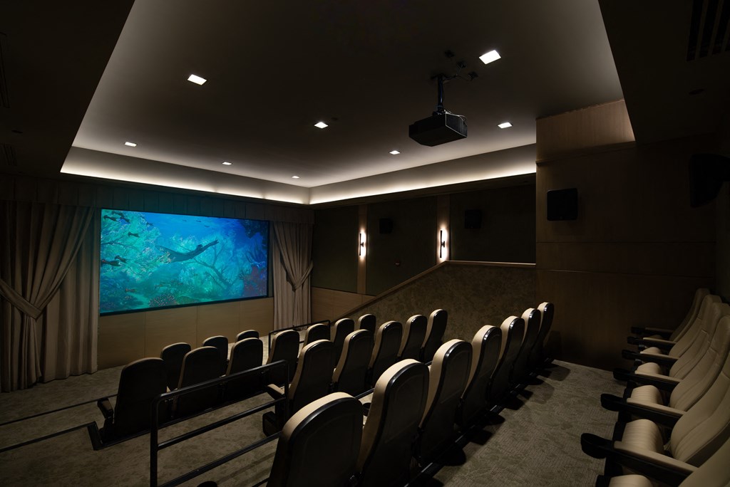 A row of black chairs are set up in front of a large screen.