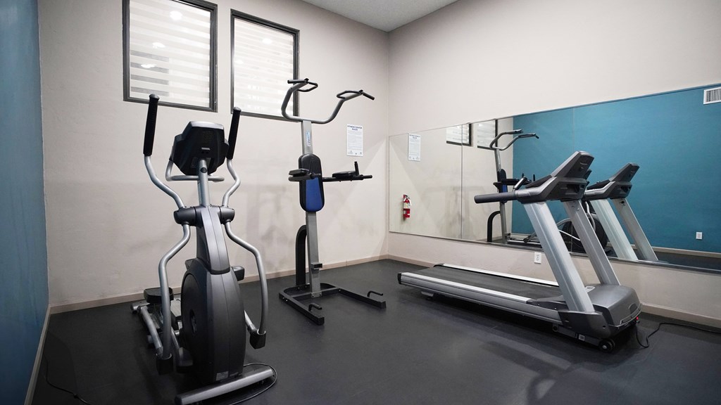 A gym with a blue wall and a treadmill.