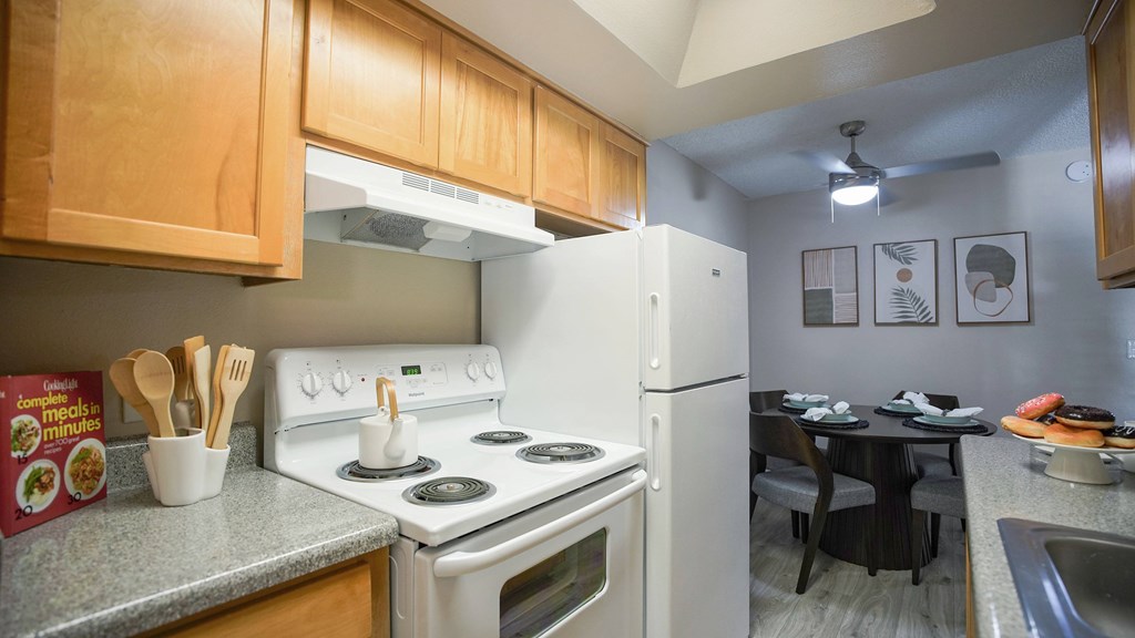 A kitchen with a white stove and refrigerator.