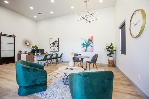 A living room with a green chair in the foreground and a dining area in the background.