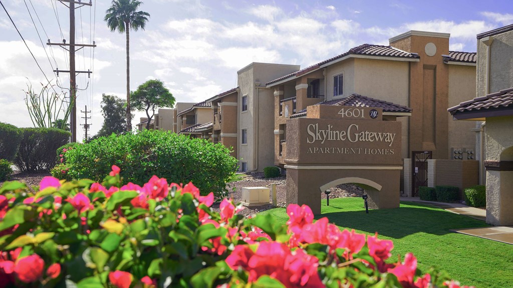 The image shows a beautiful view of the Skyline Gateway Apartment Homes entrance with a sign that reads "4601 Skyline Gateway Apartment Homes".