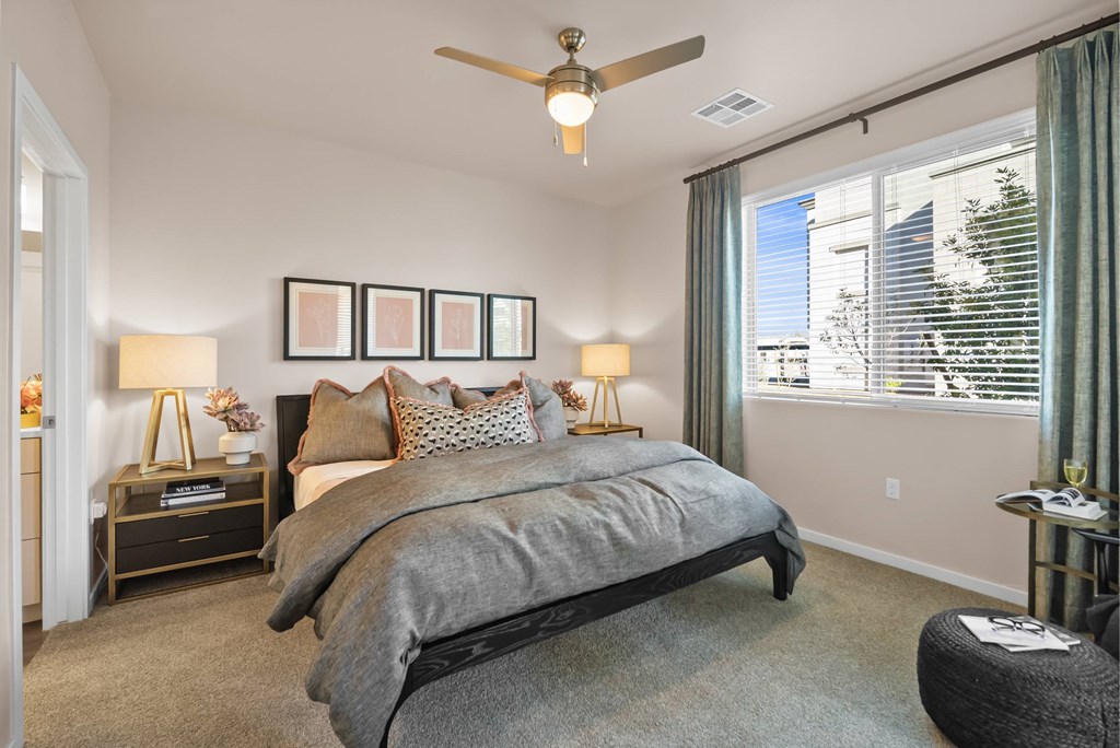 A bedroom with a large bed and a ceiling fan.