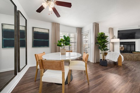 A modern dining room with a round table and chairs.