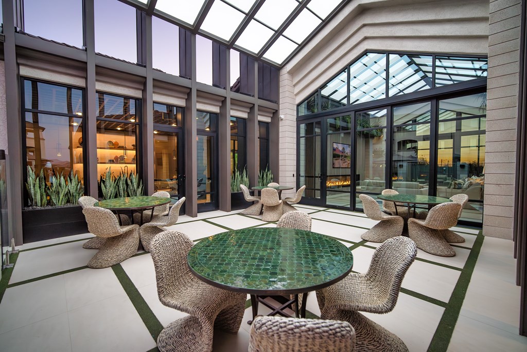 A glass-roofed room with a green table and chairs.