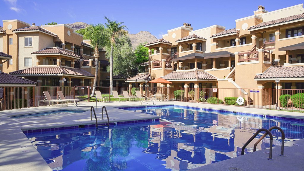 A large swimming pool in front of apartment buildings.