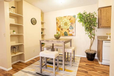 A kitchen with a dining table and chairs.