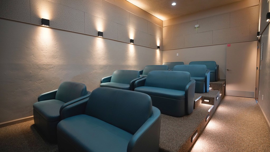 A row of blue seats in a dimly lit room.