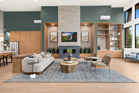 A modern living room with a large couch, a coffee table, and a TV on the wall.