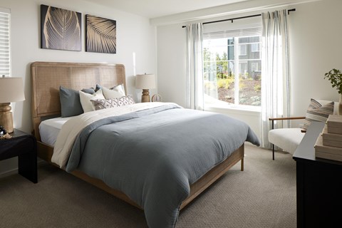 a bedroom with a bed and a large window