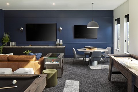 A modern living room with a pool table and a television.