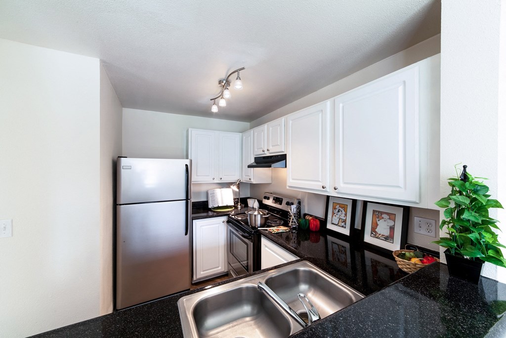 a kitchen with white cabinets and stainless steel appliances