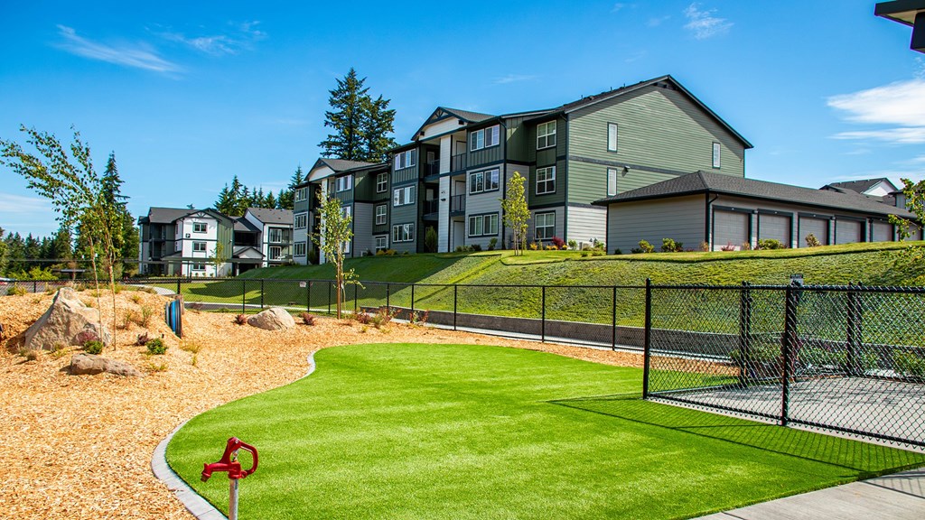 A red flag marks the corner of a well-kept lawn in front of apartment buildings.