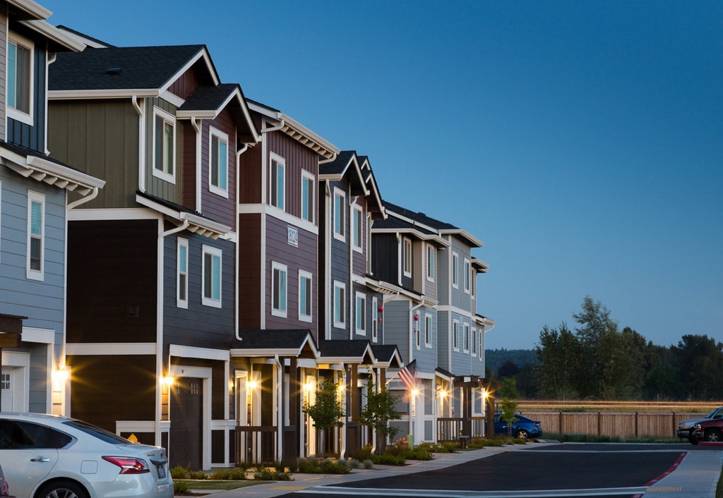 a row of townhomes with cars parked in front of them