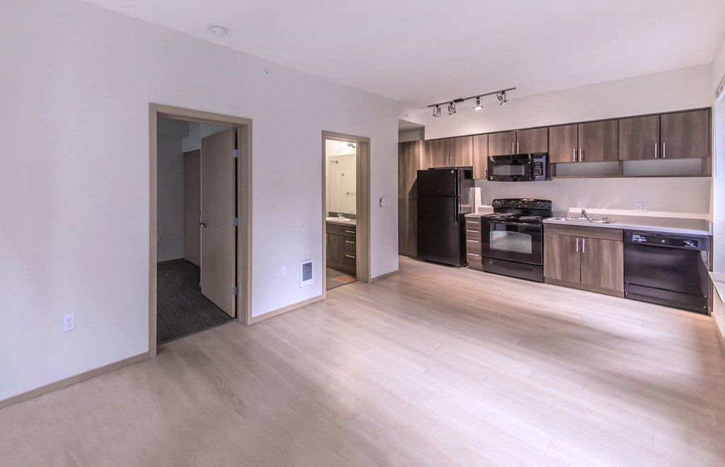 a kitchen and living room with wood flooring and black appliances