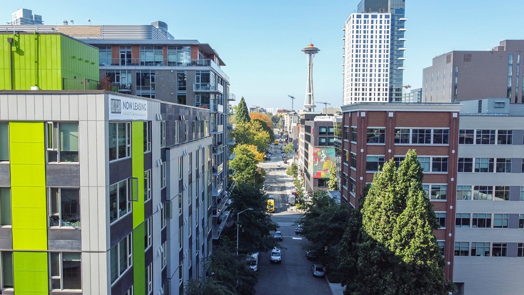 a view of a city street with tall buildings and trees