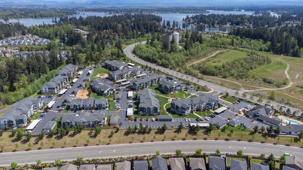an aerial view of a neighborhood of houses near a road and a lake