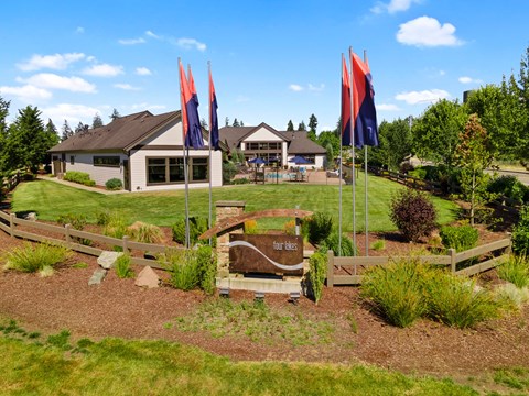 a garden with flags and a house in the background