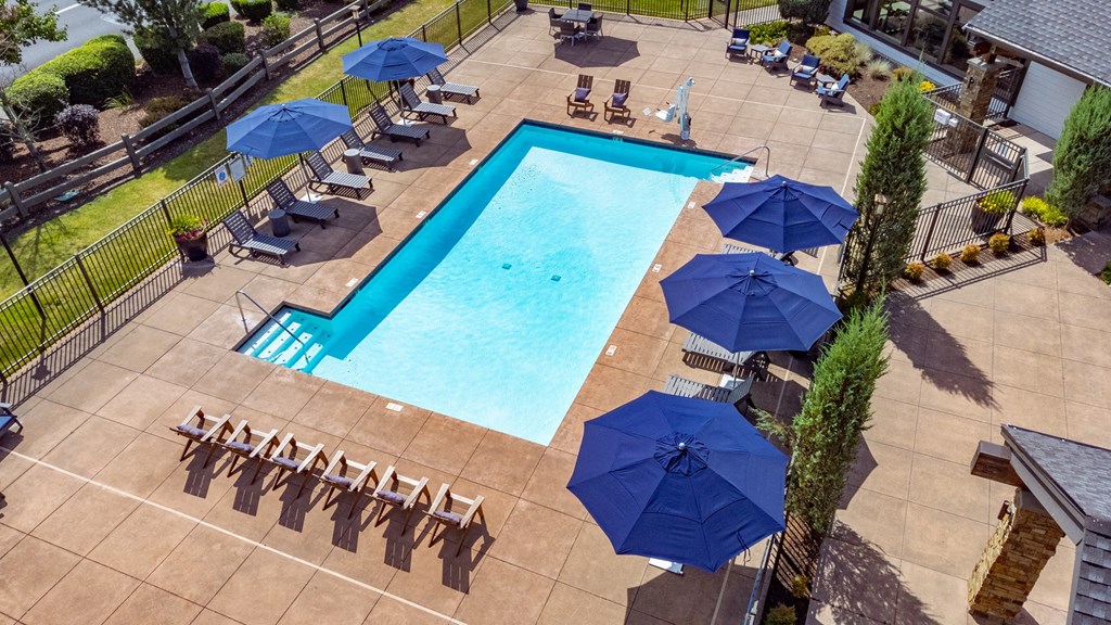 a swimming pool with umbrellas and chairs around it