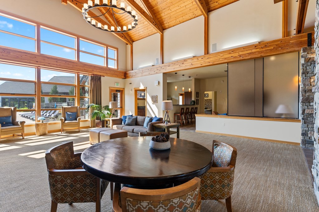 a large living room with a table and chairs