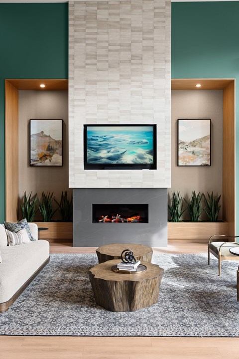 A living room with a fireplace and a painting on the wall.