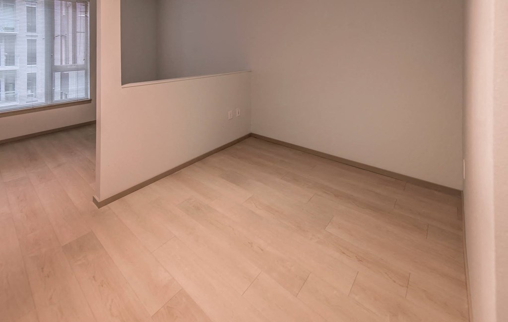 an empty room with wooden floors and a window