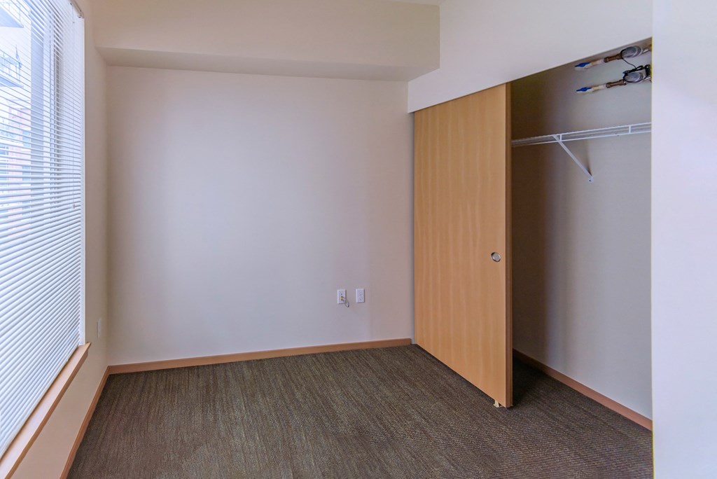 an empty room with a closet and a window