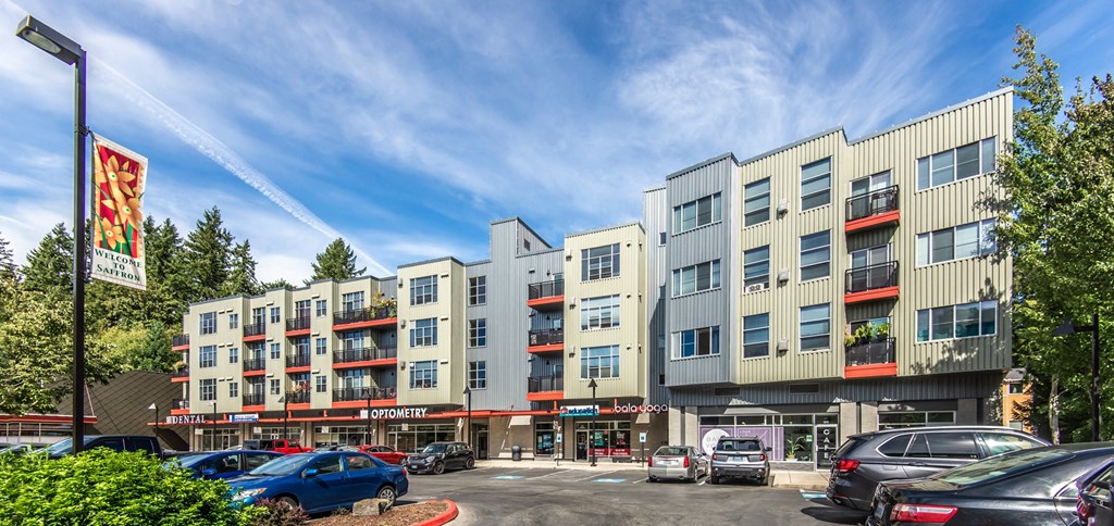 an image of an apartment building with cars parked in front of it