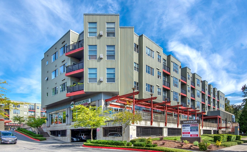 a large apartment building on a street with a sign in front