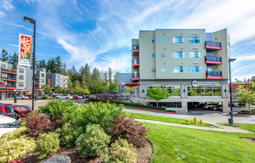 a city building with a green lawn and a sign in front of it