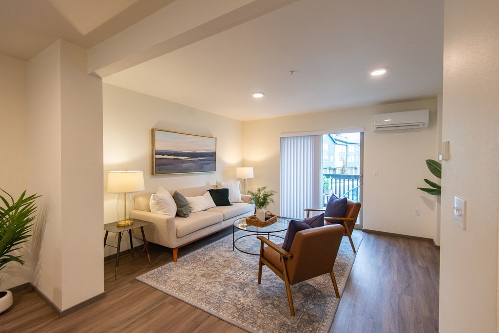 a living room with a couch and a chair and a window