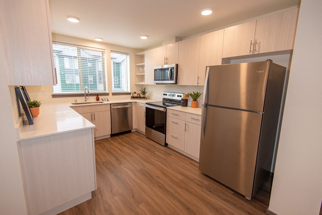 a kitchen with white cabinets and stainless steel appliances