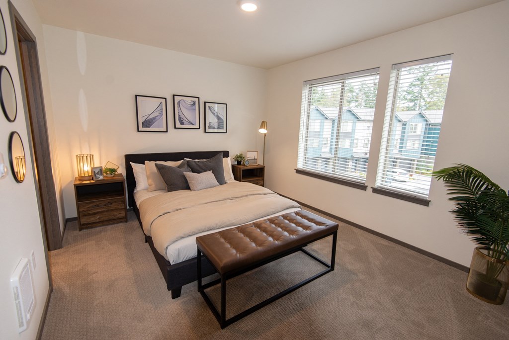 a bedroom with a bed and a large window