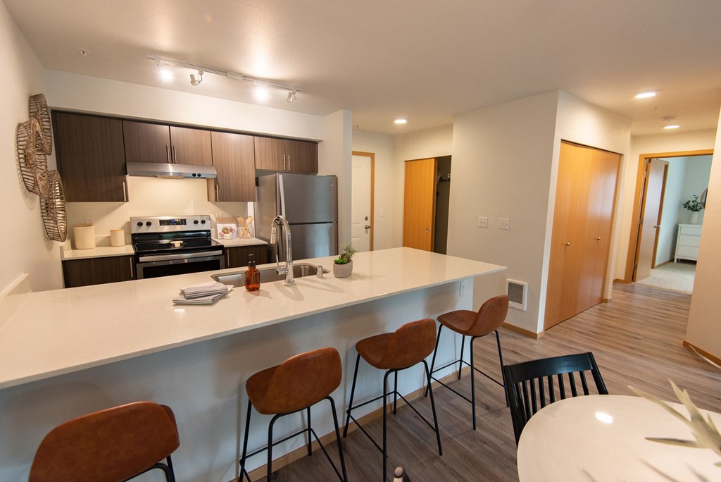 a kitchen and dining area with a large counter and chairs in a apartment