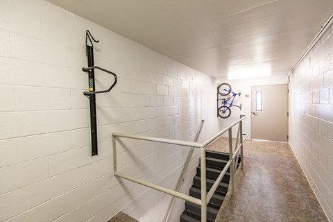 a staircase with railings and a bike rack on the wall