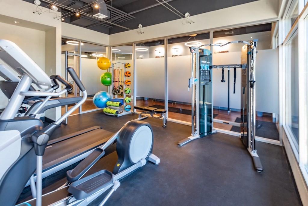 a gym with cardio equipment and weights on a floor
