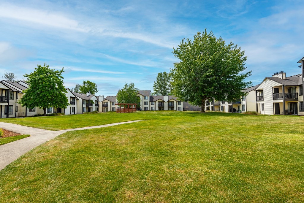 a grassy area with houses in the background