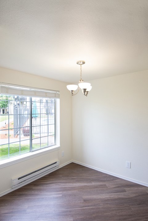 an empty room with a large window and a chandelier