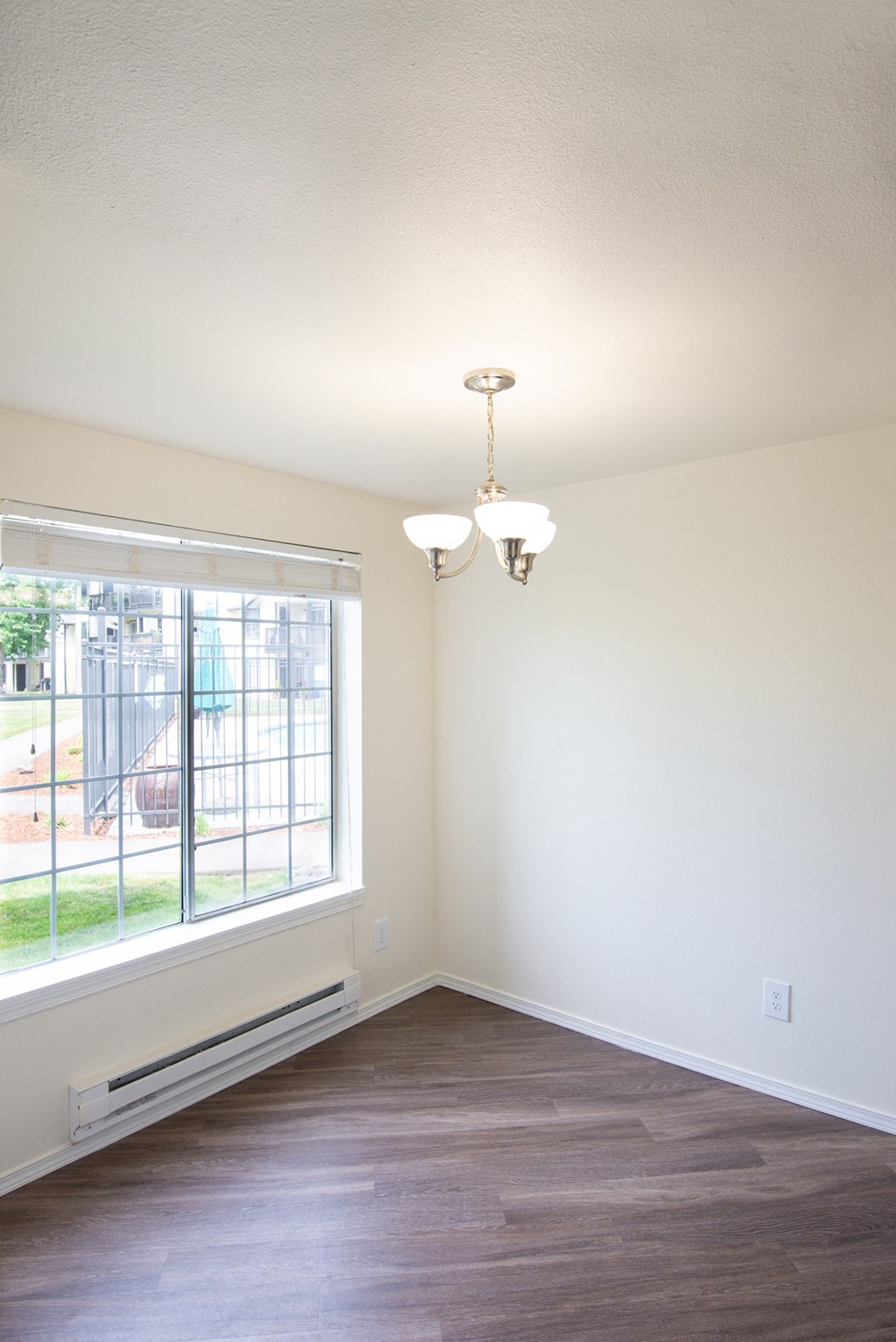 an empty room with a large window and a chandelier